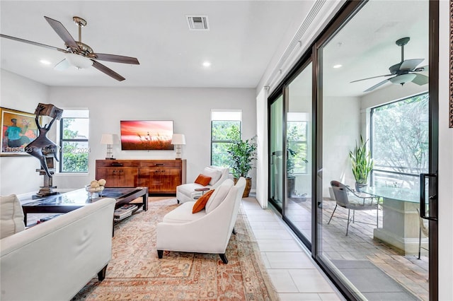 living room featuring ceiling fan and a healthy amount of sunlight