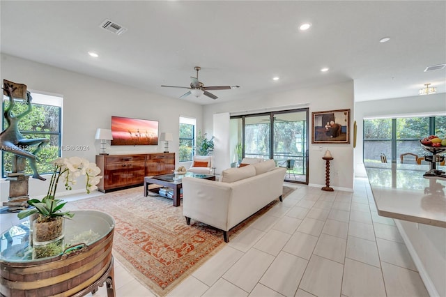 living room featuring light tile patterned floors, ceiling fan, and plenty of natural light