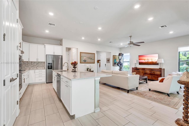 kitchen with white cabinets, stainless steel appliances, and plenty of natural light