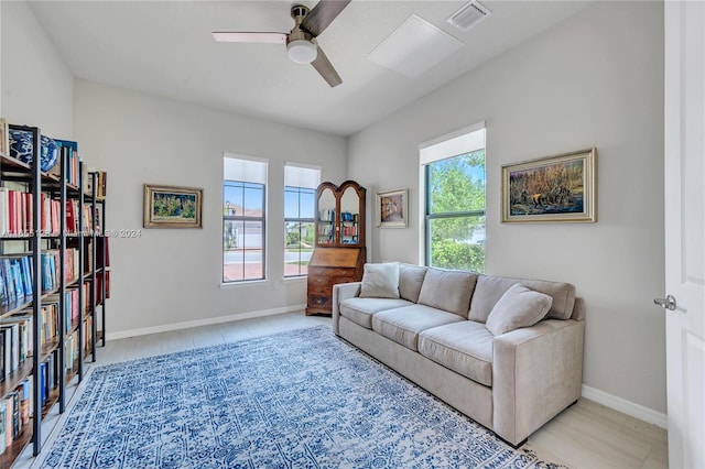 living room with ceiling fan, plenty of natural light, and light tile patterned floors