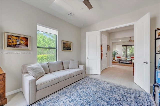 living room featuring ceiling fan and a healthy amount of sunlight