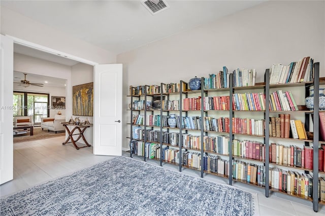 living area with ceiling fan and light tile patterned flooring