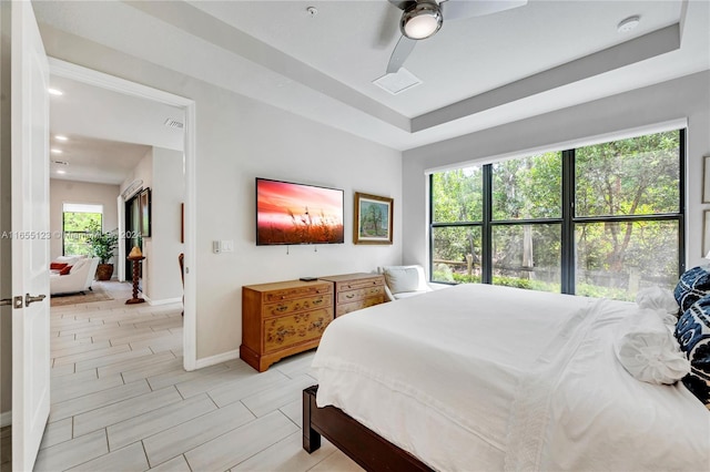 bedroom with ceiling fan and a tray ceiling