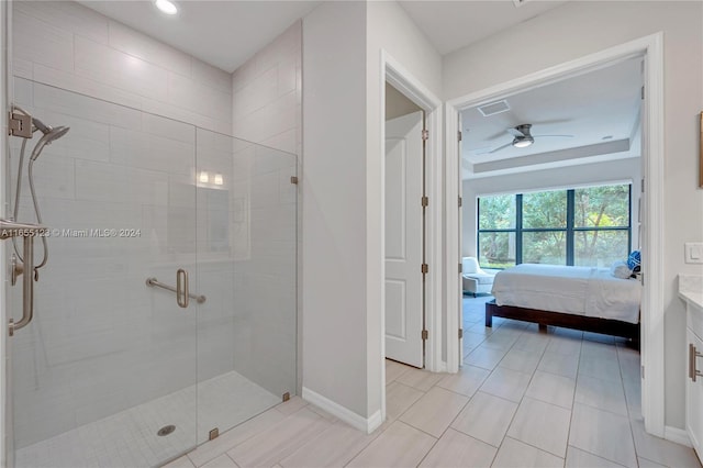 bathroom with ceiling fan, vanity, a raised ceiling, tile patterned floors, and a shower with door