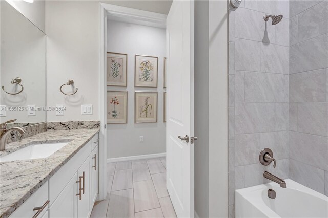 bathroom with tiled shower / bath and vanity