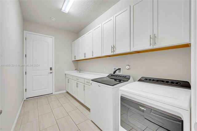 laundry area with cabinets, a textured ceiling, sink, and washing machine and clothes dryer