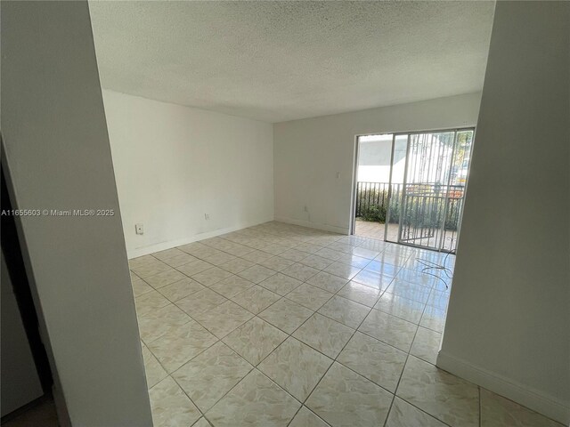 tiled spare room featuring a textured ceiling