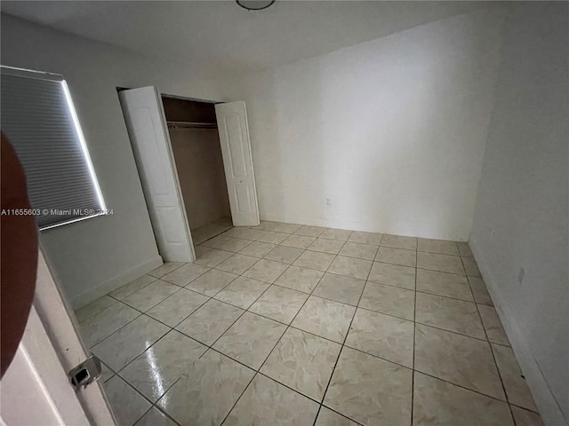 unfurnished bedroom with a closet and light tile patterned flooring