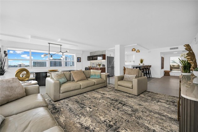 tiled living room with an inviting chandelier