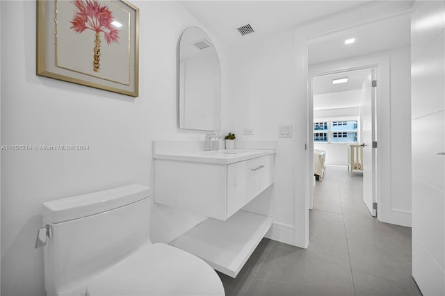 bathroom featuring tile patterned flooring, vanity, and toilet