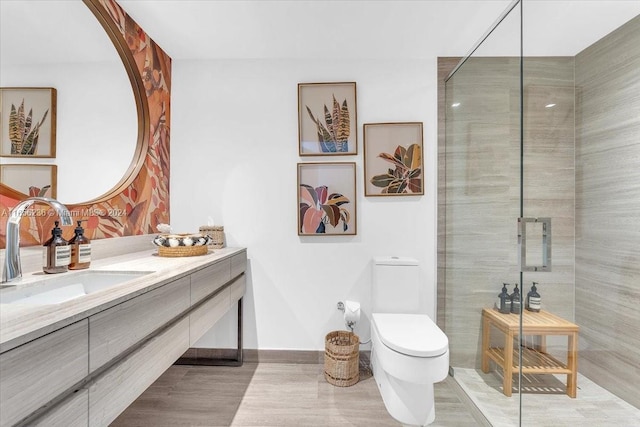 full bath with a tile shower, toilet, and vanity