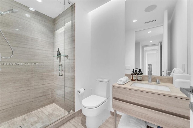 bathroom with visible vents, toilet, a stall shower, and vanity