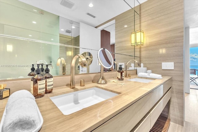 bathroom with wood-type flooring, an enclosed shower, and vanity