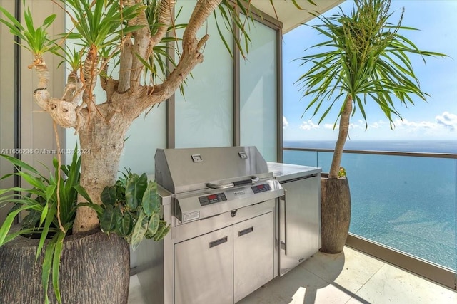 view of patio featuring an outdoor kitchen, a balcony, and a water view