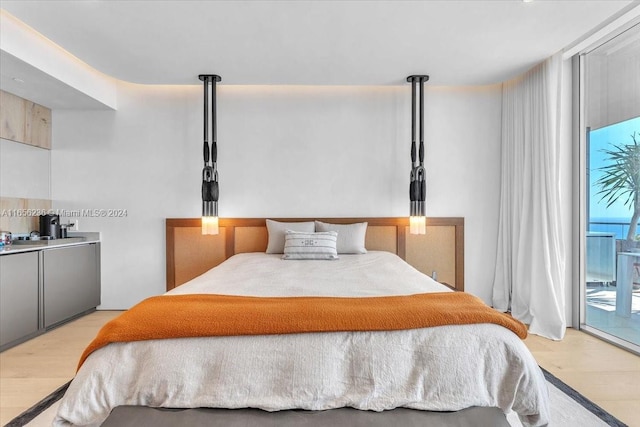 bedroom with access to outside and light wood-type flooring