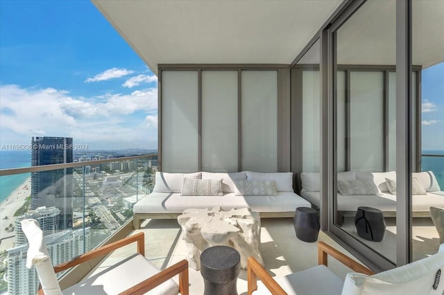 balcony with an outdoor living space, a view of city, and a water view