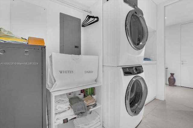 clothes washing area featuring electric panel, laundry area, and stacked washer and dryer