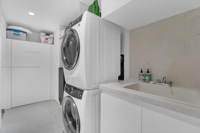 laundry room featuring stacked washer and clothes dryer and sink