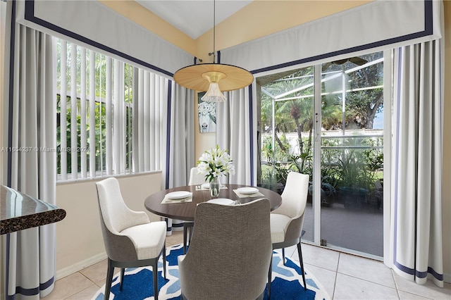 dining space with light tile patterned floors and vaulted ceiling