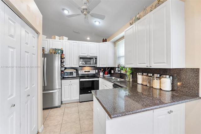 kitchen with sink, kitchen peninsula, white cabinetry, stainless steel appliances, and vaulted ceiling