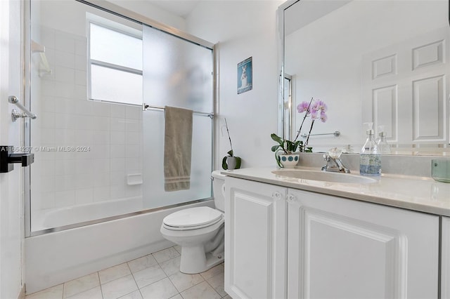 full bathroom featuring vanity, toilet, tile patterned flooring, and bath / shower combo with glass door