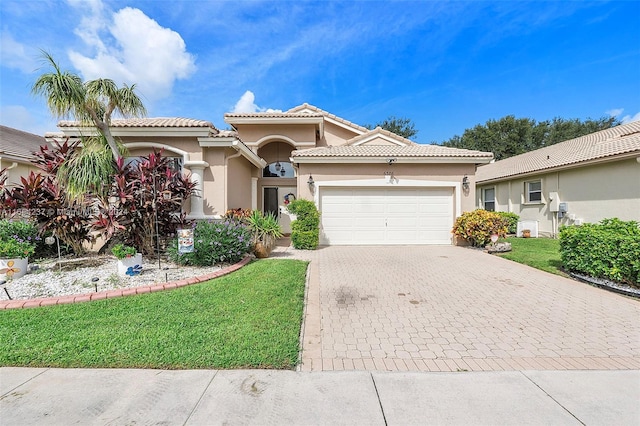 mediterranean / spanish-style house with a front lawn and a garage