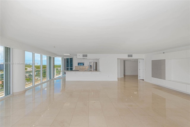 unfurnished living room with sink and light tile patterned flooring