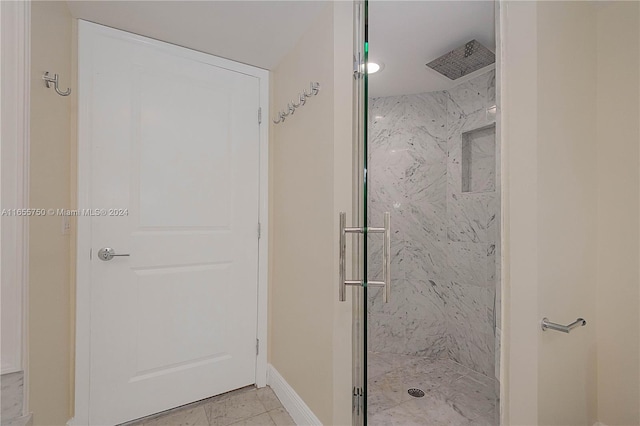 bathroom featuring a shower with door and tile patterned flooring