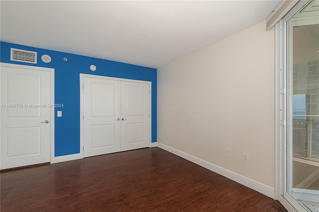 unfurnished bedroom with a closet and dark hardwood / wood-style floors