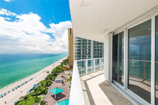 balcony featuring a beach view and a water view