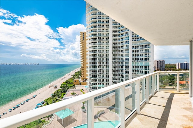 balcony with a water view and a view of the beach