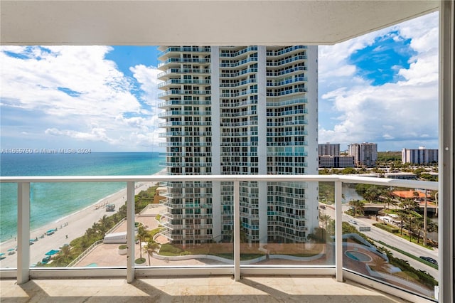 balcony featuring a view of the beach and a water view