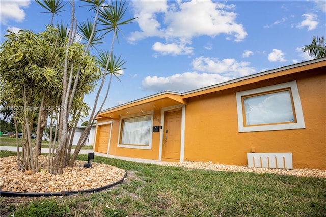 view of front of house featuring a front lawn and a garage