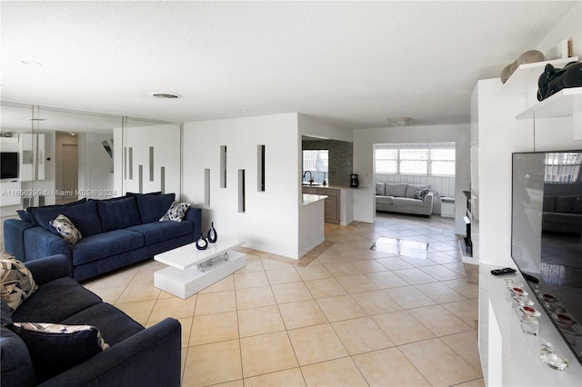 tiled living room featuring a textured ceiling and sink