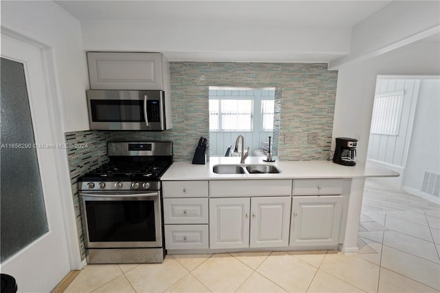 kitchen with stainless steel appliances, sink, backsplash, and light tile patterned flooring