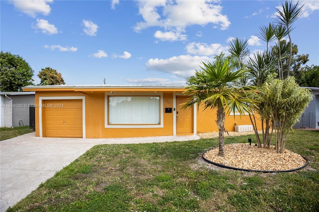 single story home featuring a garage and a front lawn