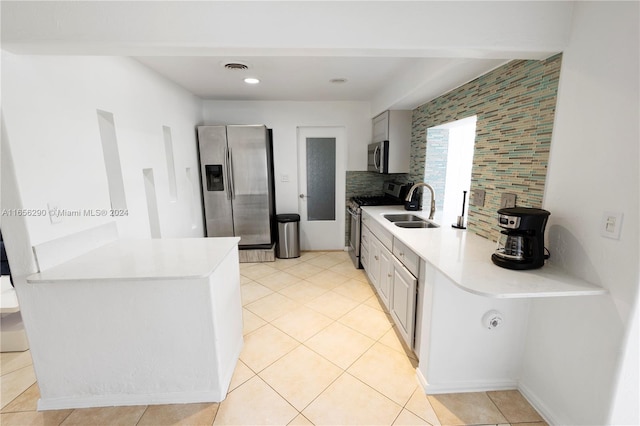 kitchen with light tile patterned floors, stainless steel appliances, sink, and decorative backsplash