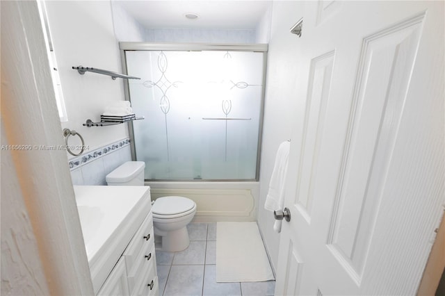 full bathroom with tile patterned flooring, vanity, toilet, and bath / shower combo with glass door