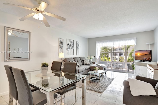 tiled dining room with ceiling fan and a textured ceiling