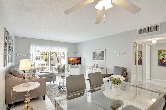 dining area with a textured ceiling, ceiling fan, and light tile patterned flooring