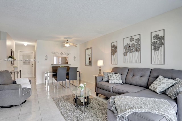 tiled living room with a textured ceiling and ceiling fan