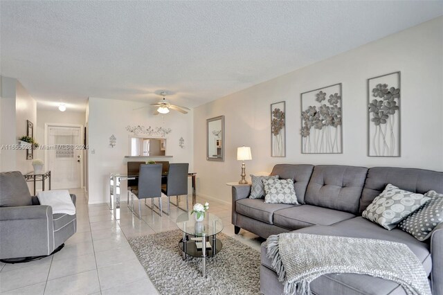 3501 NW 47th Ave Unit 516, Lauderdale Lakes, FL 33319 - living area with light tile patterned floors, a textured ceiling, ceiling fan, and baseboards
