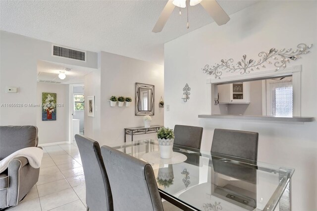 3501 NW 47th Ave Unit 516, Lauderdale Lakes, FL 33319 - dining area featuring plenty of natural light, light tile patterned floors, ceiling fan, baseboards, and a textured ceiling