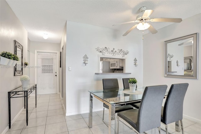 dining room with a textured ceiling, ceiling fan, and light tile patterned floors