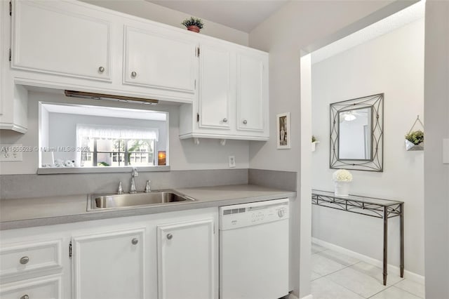 kitchen with white cabinets, dishwasher, light tile patterned floors, and sink