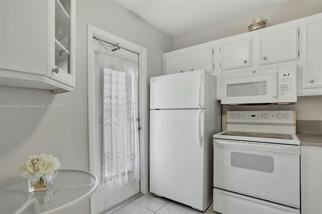 kitchen with white appliances, light tile patterned floors, and white cabinets