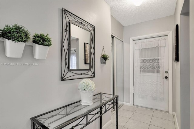 3501 NW 47th Ave Unit 516, Lauderdale Lakes, FL 33319 - foyer entrance with a textured ceiling, light tile patterned flooring, and baseboards