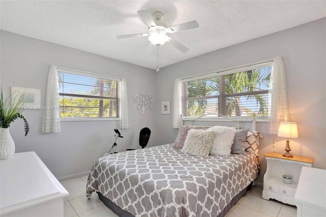 bedroom featuring multiple windows, ceiling fan, and light tile patterned floors