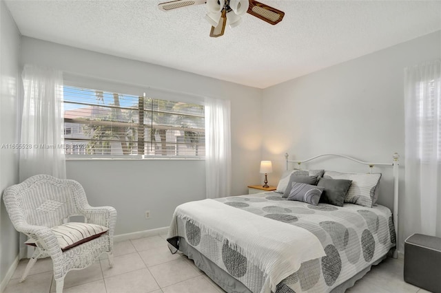 bedroom featuring ceiling fan, a textured ceiling, and light tile patterned flooring