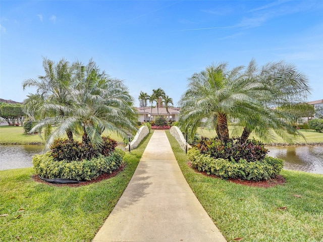 view of property's community with a yard and a water view